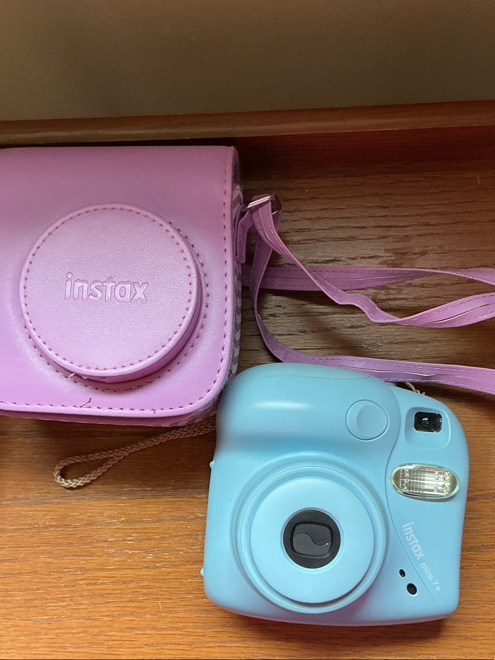 Instax Mini instant camera in light blue with pink carrying case